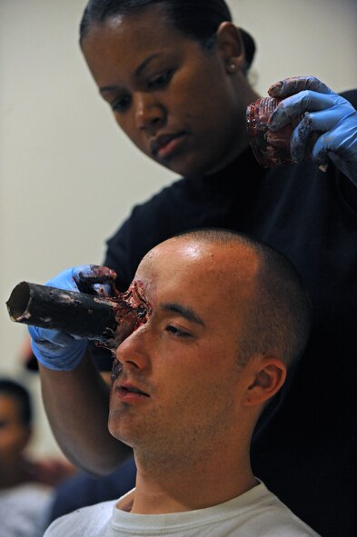 Staff Sergeant Robrielle Dotson, 2nd Medical Group, applies moulage to Airman 1st Class Joshua Zermeno, 2nd Maintenance Squadron, in preparation for the Major Accident Response Exercise on Barksdale Air Force Base, La., April 29. Moulage is an art form that involves applying fake wounds to healthy individuals to provide realism during training involving first responders. (U.S. Air Force photo/Airman 1st Class Micaiah Anthony)(RELEASED)