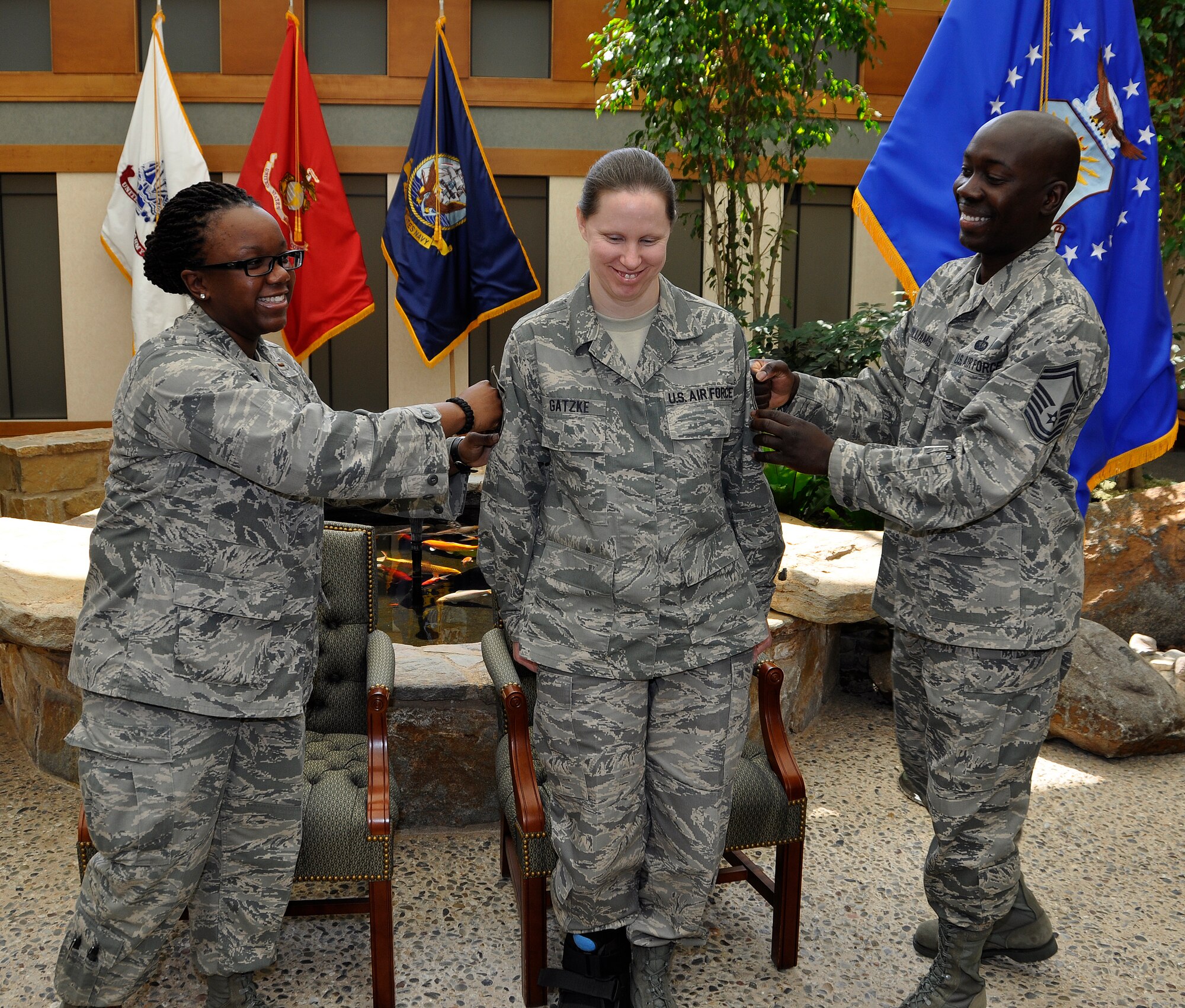 Tech. Sgt. Kathy Gatzke (center) braces as 2nd Lt. Keturah Johnson and Senior Master Sgt. Tyrone Williams help her tack on master sergeant stripes during a promotion ceremony April 29,2011 at the Charles C. Carson Center for Mortuary Affairs. Sergeant Gatzke is deployed to Air Force Mortuary Affairs Operations from the 28th Force Support Squadron at Ellsworth Air Force Base, S.D. (U.S. Air Force photo/Tech. Sgt. Michael Stewart)
