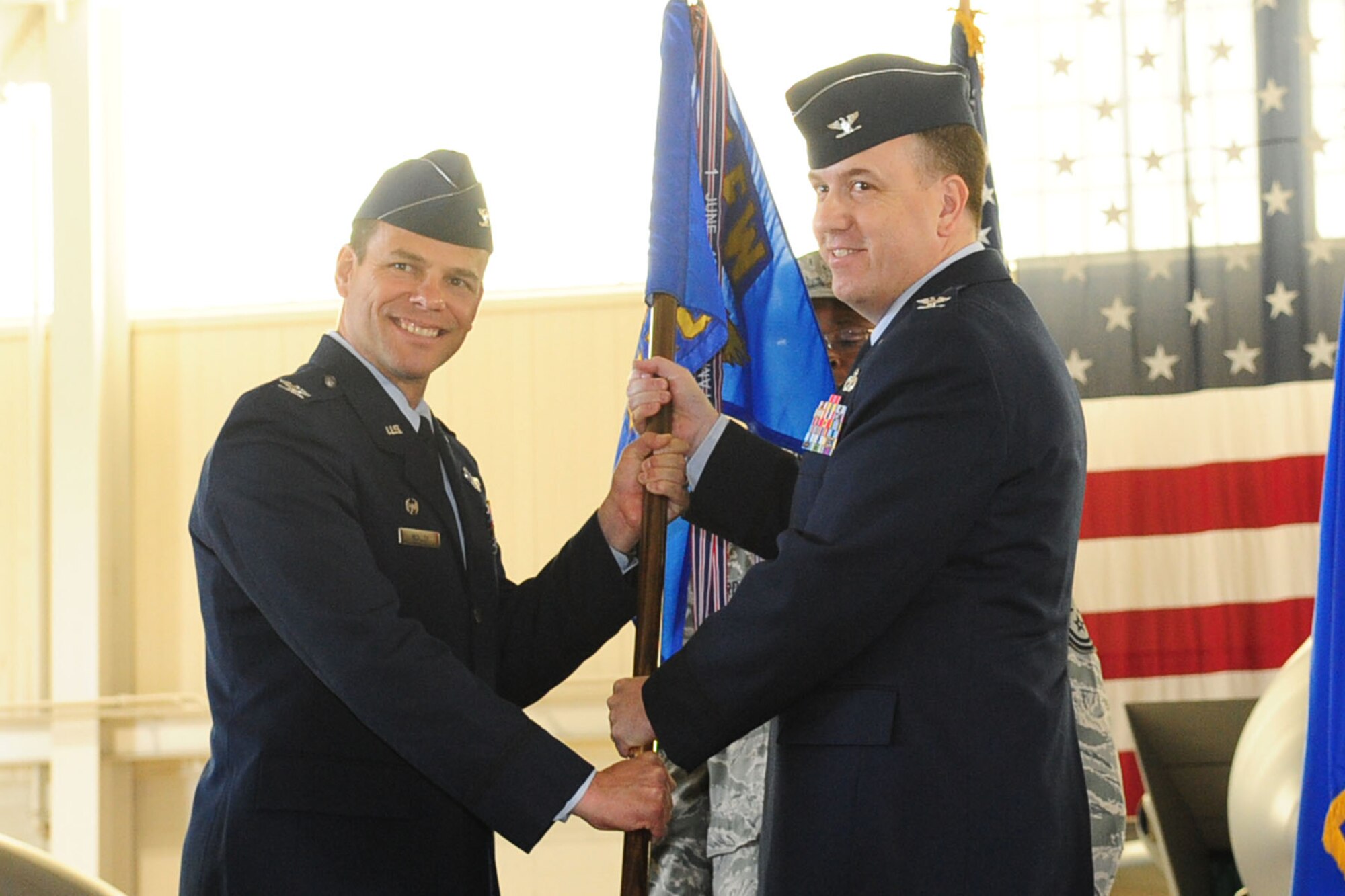Col. Matthew Molloy, 1st Fighter Wing commander, passes the guidon to Col. Matthew Vanzke, during the 1st Maintenance Group change of command ceremony at Langley Air Force Base, Va., April 29, 2011. Col. Venzke succeeded Col. George Zaniewski as commander of the Group. (U.S. Air Force photo by Staff Sgt. Ashley Hawkins/Released)