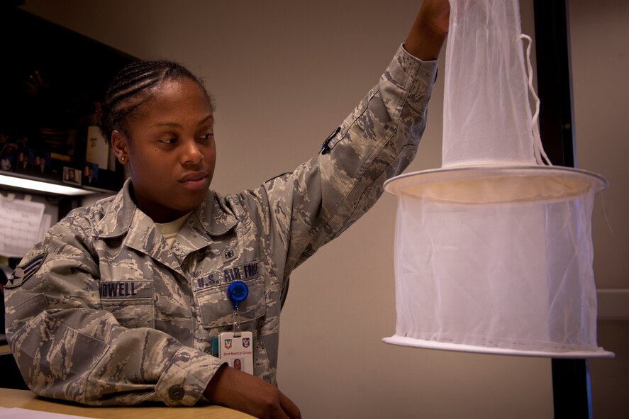 MOODY AIR FORCE BASE, Ga.-- Senior Airman Andrea Treadwell, 23rd Medical Group public health journeyman, holds up a mosquito net, inspecting it for female mosquitoes April 29. The traps were placed at areas on base where mosquitoes are most active. Once captured, the female mosquitoes are frozen and sent off to Wright-Patterson Air Force Base, Ohio, to see if the insects were carrying any diseases. (U.S. Air Force/Airman 1st Class Joshua Green)(RELEASED)
