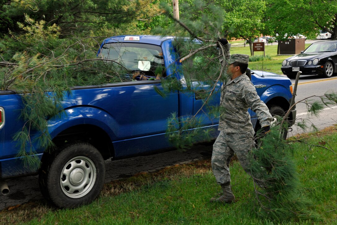 Airman First Class Leonard Sylva, 11 Civil Engineer Squadron water and fuel system maintenance apprentice, picks up branches from damaged tree that resulted from a severe storm April 28.  The storm Wednesday night was part of the deadly storms that have demolished homes across the United States. (U.S. Air Force photo by Senior Airman Melissa V. Brownstein)