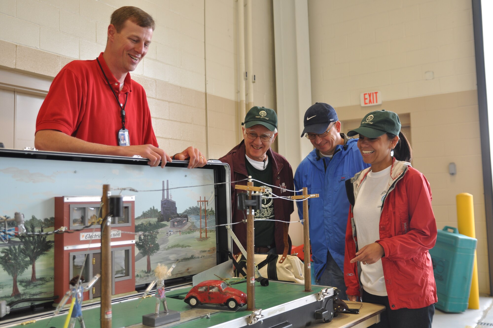 Richard Foster, Tennessee Valley Authority power utilization engineer, shows Frank Lockhart, Mike Clythe and Renae Fischer, 14th Flying Training Wing Civil Engineering natural resources management flight, a booth designed to help explain the properties of electricity on April 22 at the fire station. The booth was one of many shown to 450 4th graders from local schools. (U.S. Air Force photo/Airman 1st Class Chase Hedrick)