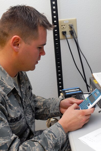 Airman 1st Class Jeffrey Borland, 56th Component Maintenance Squadron Precision Measurement Equipment Laboratory apprentice, calculates measurement correction factors which will allow him to determine true output power values April 7 during the calibration of a Microwave Measurement Receiver Power Sensor Module. (U.S. Air Force photo by Senior Airman Tracie Forte)
