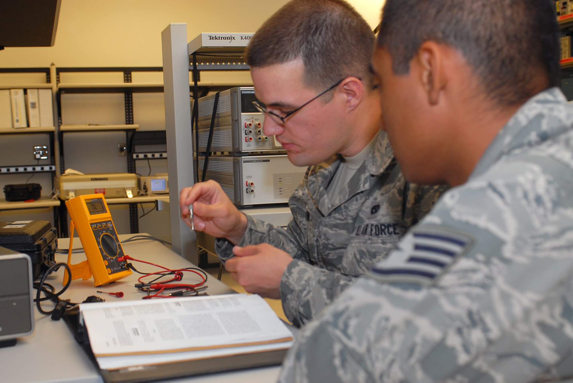 Staff Sgt. Steven Umana, 56th Component Maintenance Squadron Precision Measurement Equipment Laboratory (PMEL) journyeman, evaluates Airman 1st Class David Munn, 56th Component Maintenance Squadron PMEL apprentice, April 7 on his ability to correctly perform an input power safety inspection. This inspection is required on every piece of electrical and electronic support equipment that enters PMEL. (U.S. Air Force photo by Senior Airman Tracie Forte)
