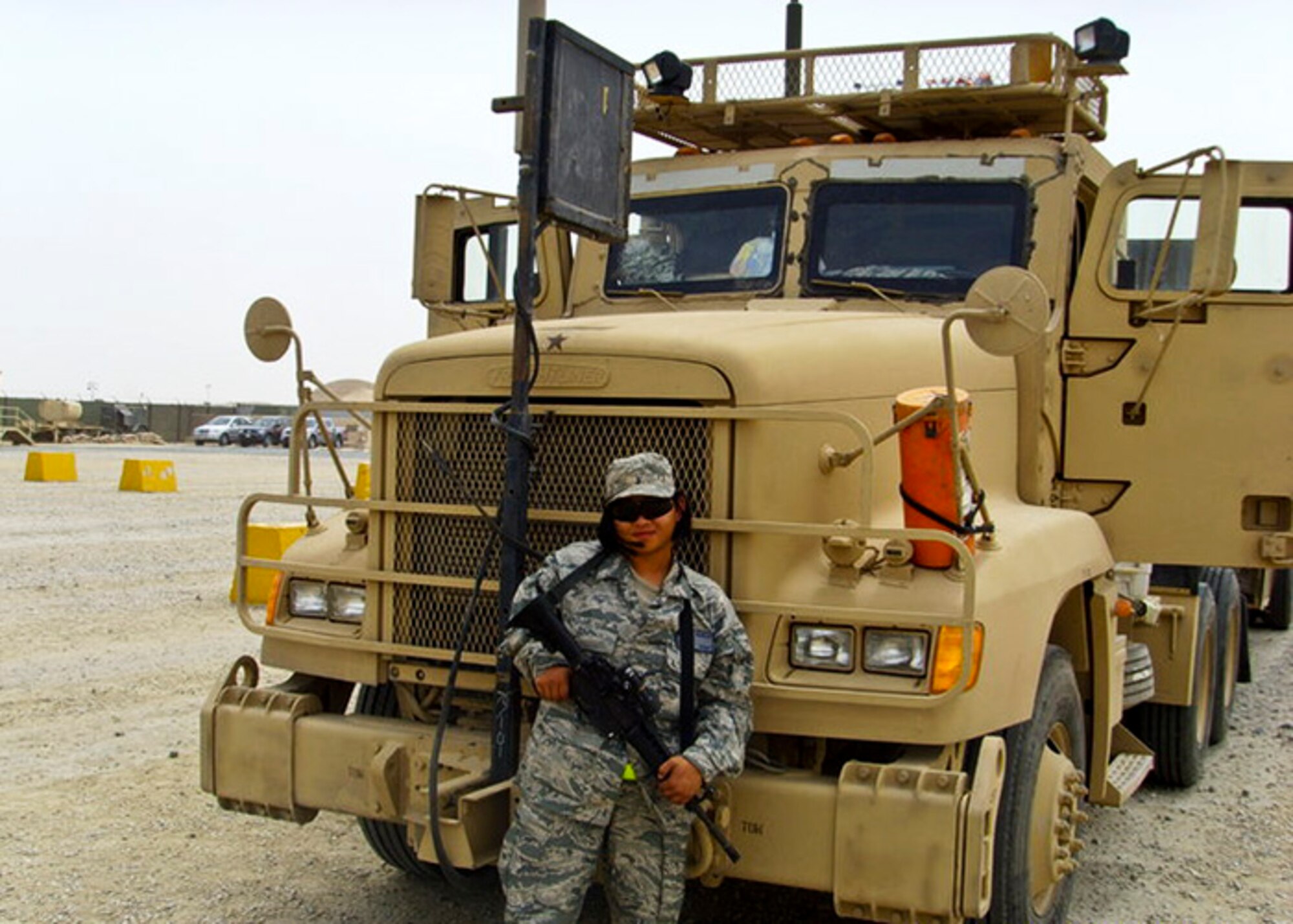 Senior Airman Michelle Wamsley, 96th Logistics Readiness Squadron, stands by her vehicle during her recent deployment in 2010.  When they deploy, Eglin’s vehicle operators shift gears from bus drivers and dispatchers to “combat truckers” hauling critical cargo in convoys to and from Iraq.  (Courtesy photo)