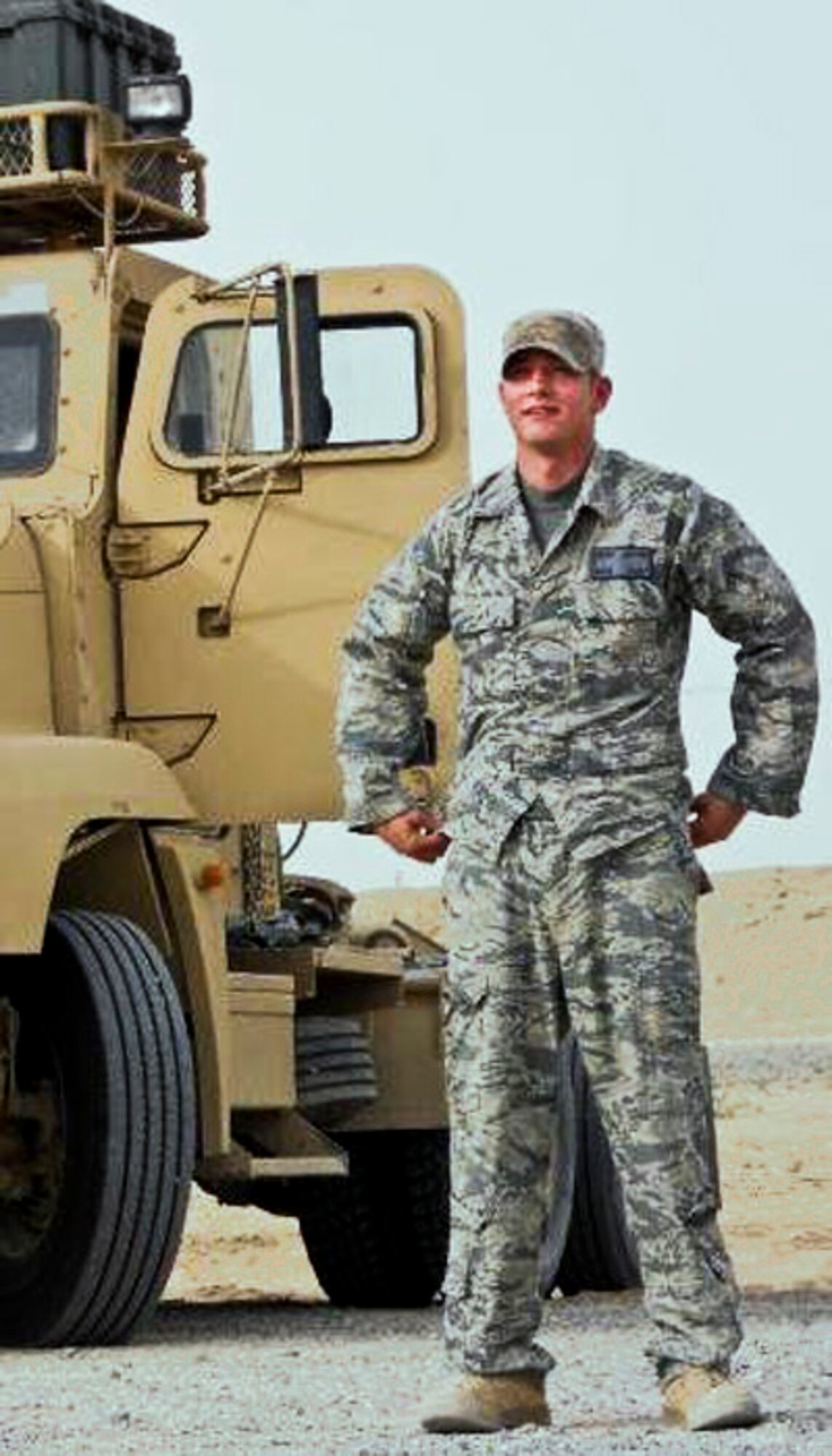 Staff Sgt. Jacob Sutton, 96th Logistics Readiness Squadron, stands by his vehicle during his recent deployment in 2010.  When they deploy, Eglin’s vehicle operators shift gears from bus drivers and dispatchers to “combat truckers” hauling critical cargo in convoys to and from Iraq.  (Courtesy photo)