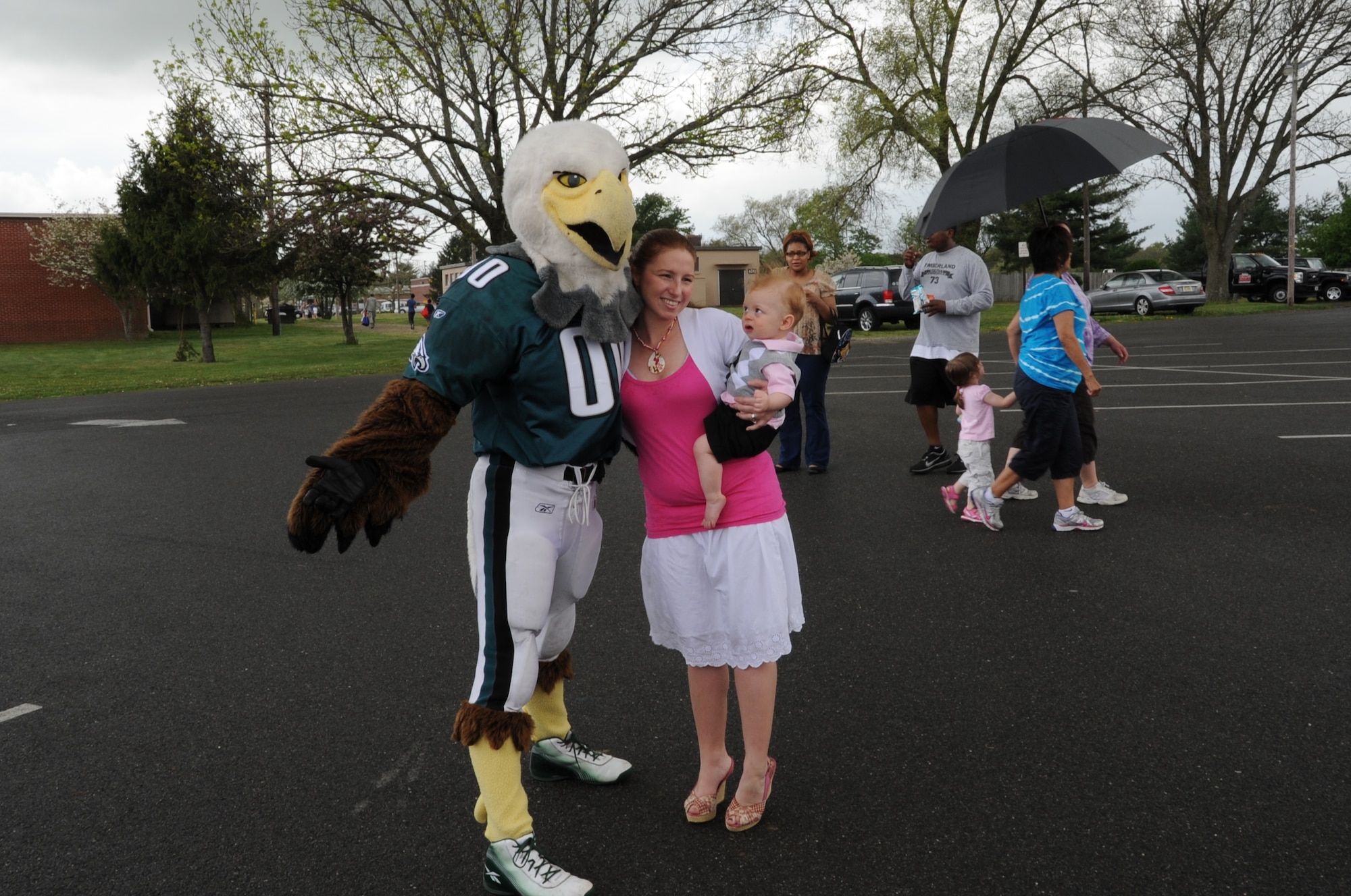 Swoop, the Philadelphia Eagle mascot, took time off from training to pose with Nicole Smith as her son Caleb eyes the big bird at the Joint Base McGuire-Dix-Lakehurst Family Fun Fest. More than 1,000 members of the community attended this years’ fun fest. (U.S. Air Force photo by Pascual Flores/Released)
