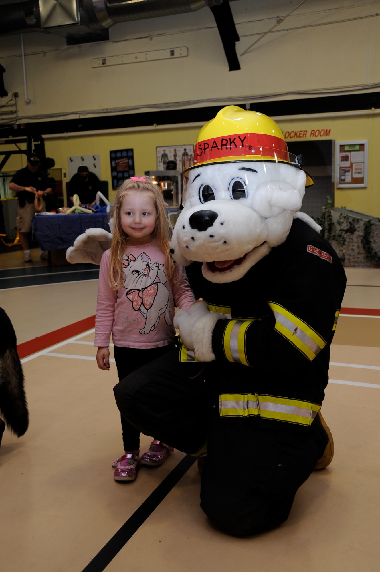 Katarina Knight, 4, receives a friendly hug from Sparky the fire dog at the Griffith Field House during the Joint Base McGuire-Dix-Lakehurst Family Fun Fest. Katarina is visiting from Menwith Hill, England. More than 1,000 members of the community attended this years’ fun fest. (U.S. Air force photo by Pascual Flores/Released)
