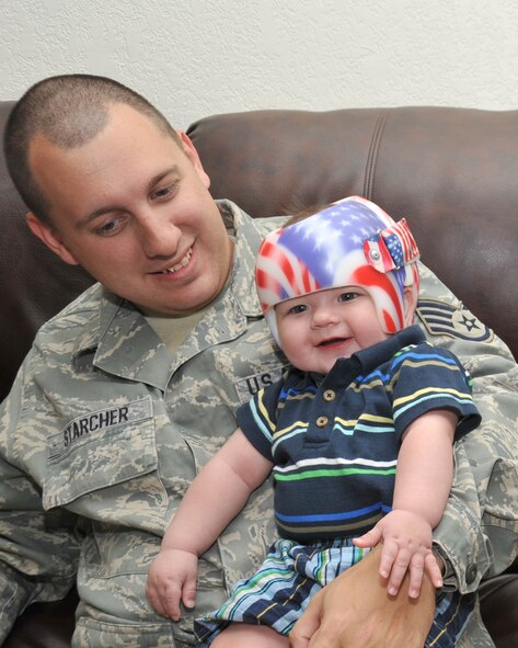 Cutline: Staff Sgt. James Starcher plays with his son Bryson at their home April 22. Assistance from the Air Force Aid Society has helped the Starcher family pay for Bryson's medical care. Sergeant Starcher is with the 802nd Logistics Readiness Squadron. (U.S. Air Force photo/Alan Boedeker)