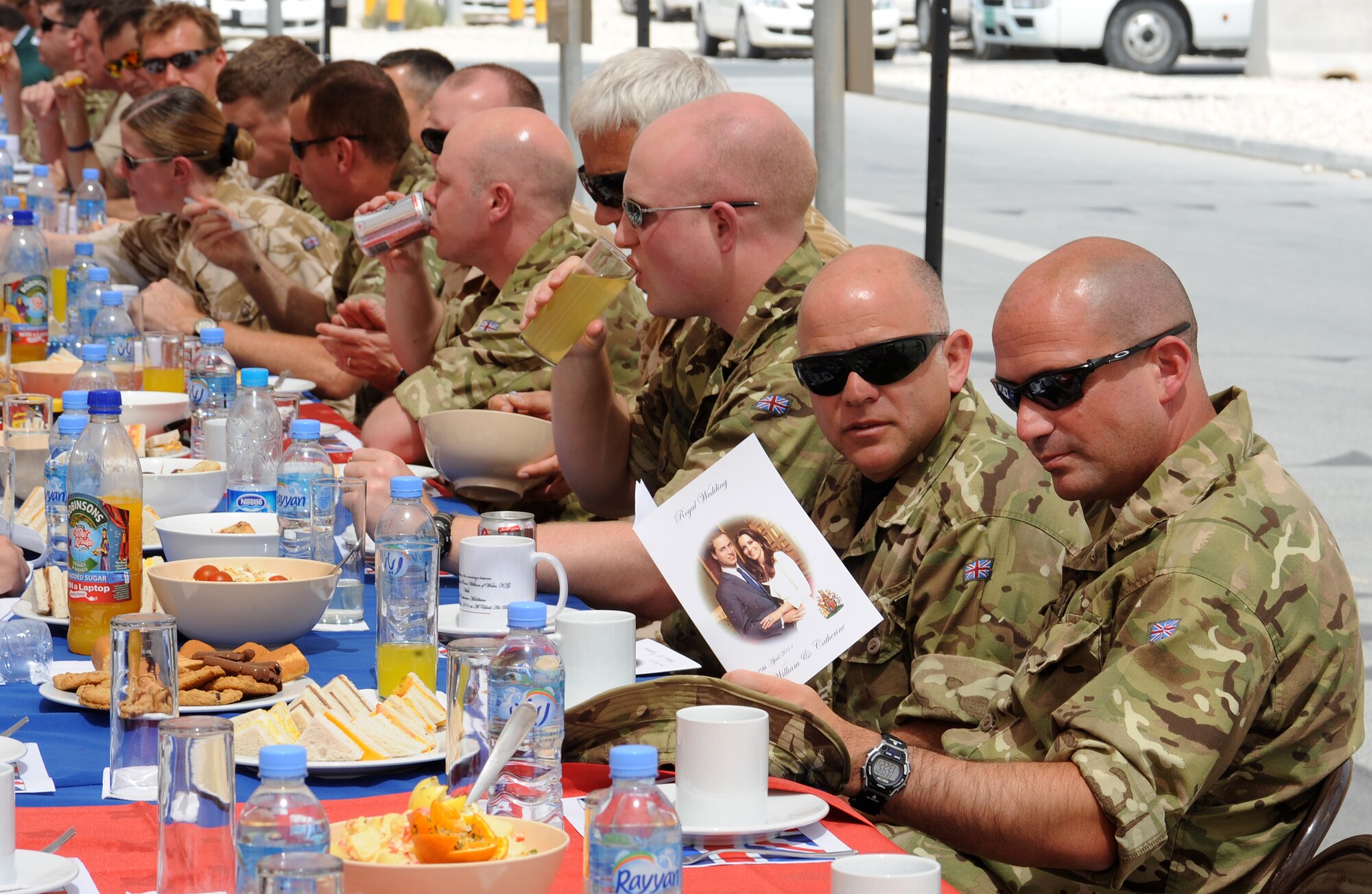 Royal Air Force Cpl. Leigh Kinroy and Sgt. Simon Gray, look over the program for the deployed members' street party celebration of the British Royal Wedding, April 29 in Southwest Asia. Street parties are a tradition which has been linked with royal and other national events for a century. (U.S. Air Force photo/Staff Sgt. Liliana Moreno)                      