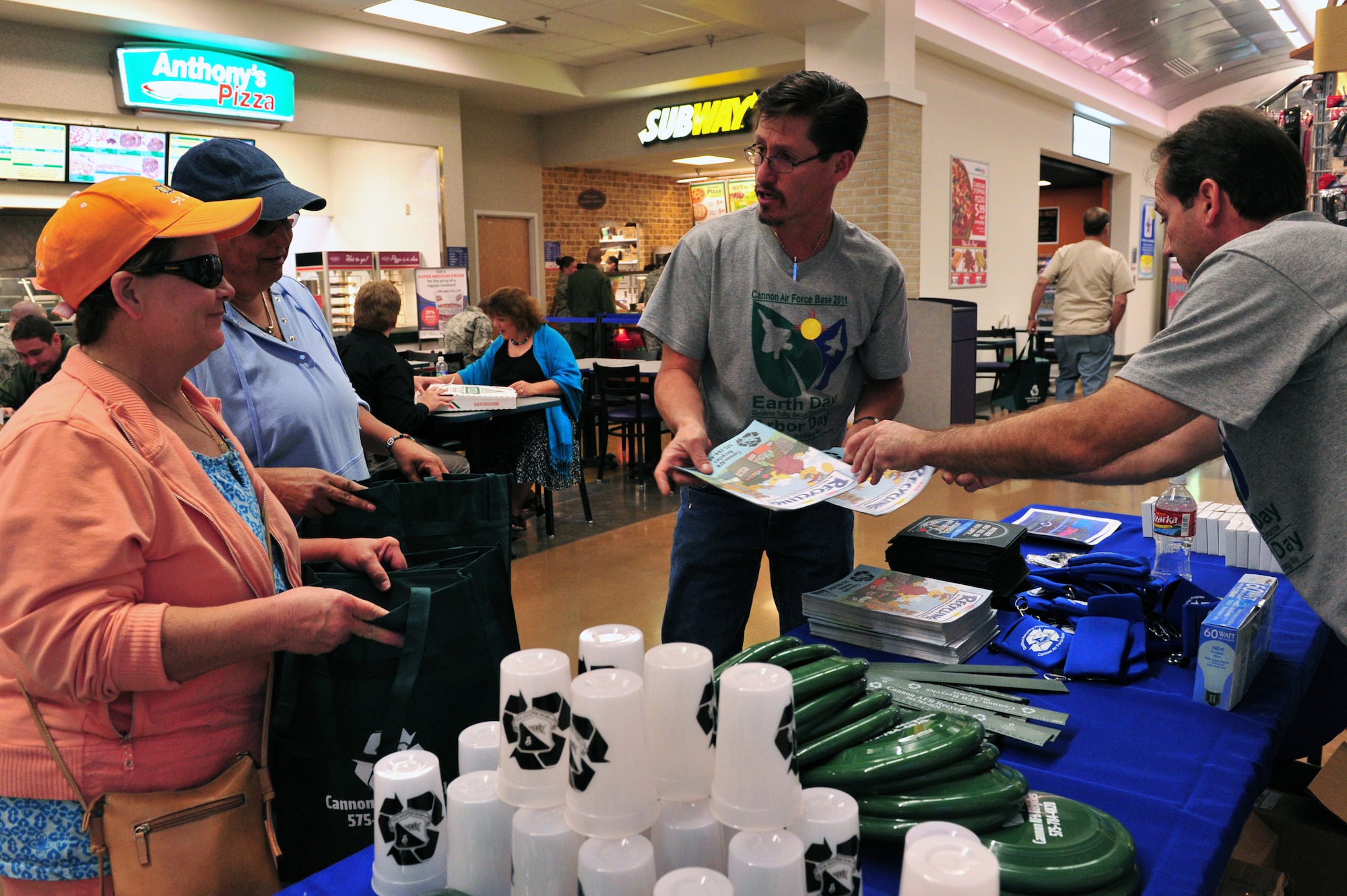 Jake Madril, center, and Mr. Bernard Manfre, 27th Special Operations Civil Engineer Squadron speak with Base Exchange and Commissary patrons April 28, 2011.  The Asset Management Flight of the 27th Special Operations Civil Engineer Squadron handed out information, reusable cups and souvenirs in support of Earth Day and Arbor Day. (U.S. Air Force photo by Tech. Sgt. Josef Cole)(RELEASED)