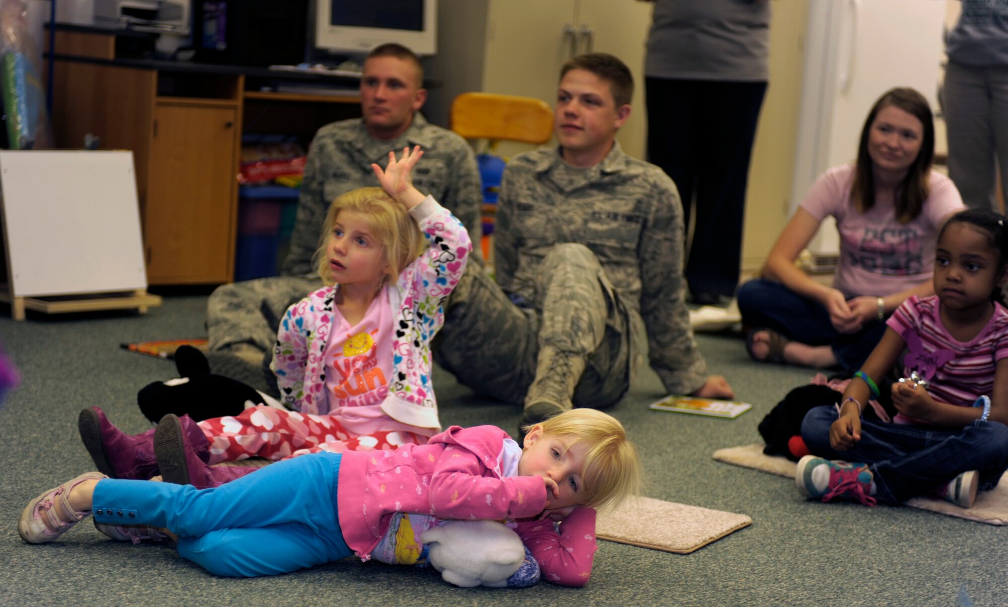 (Left to right) Alexandria and Madeline Rayo and Zaria Lewis listen to a story at the Clovis-Carver Public Library in Clovis, N.M., April 28, 2011.  In support of Earth Day, Cannon Air Force Base Airmen taught community children about taking care of the Earth through stories and planting seedlings. (U.S. Air Force photo by Airman Ericka Engblom)(RELEASED)