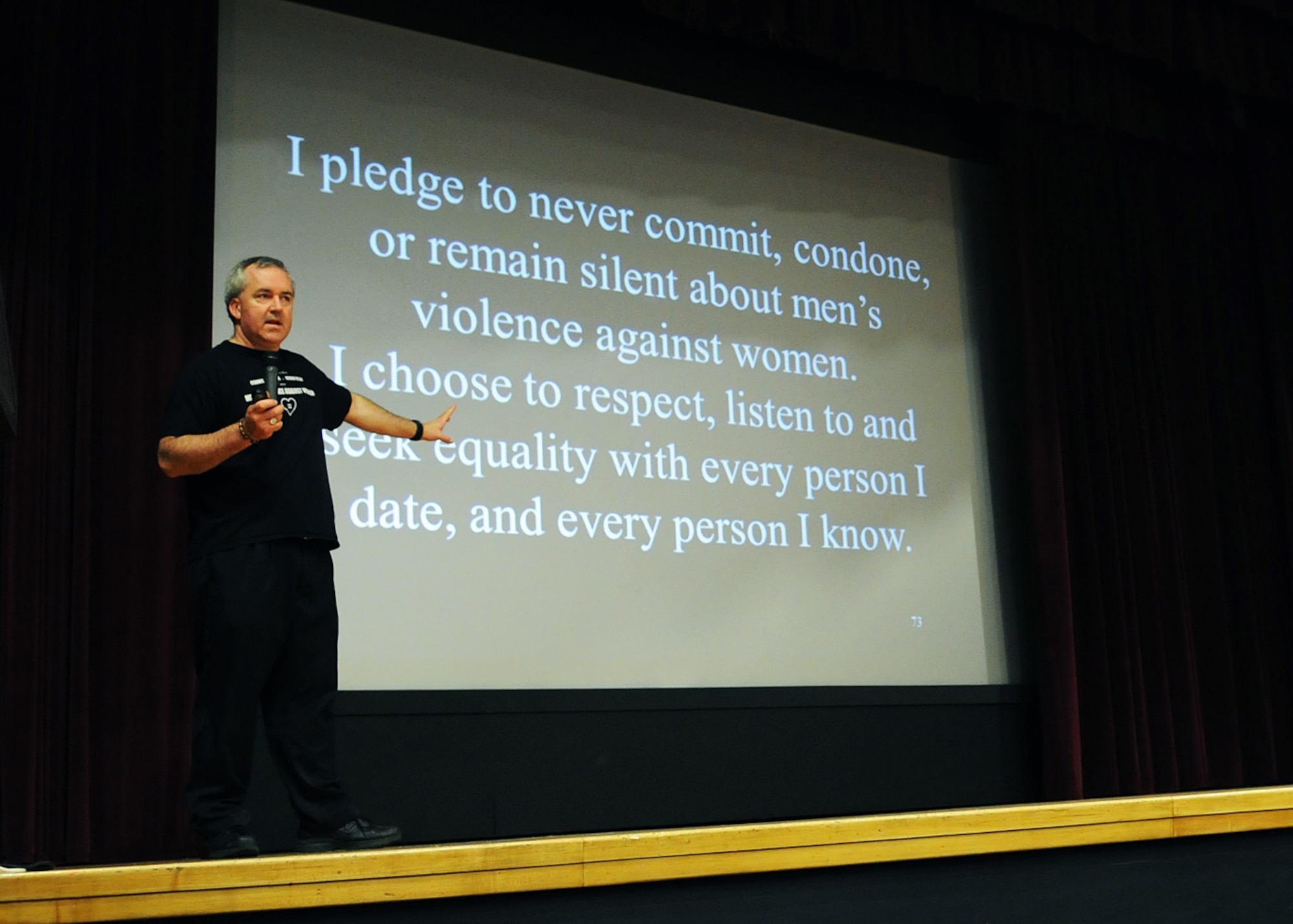RAF MILDENHALL, England -- Ben Atherton-Zeman, an instructional speaker, has volunteers from his audience at the base theater here April 26, 2011, recite a pledge to prevent violence against women. During the one-man show, Mr. Atherton-Zeman dressed as Austin Powers, Rocky and James Bond to use humor to deliver his serious message. (U.S. Air Force photo/Staff Sgt. Thomas Trower)