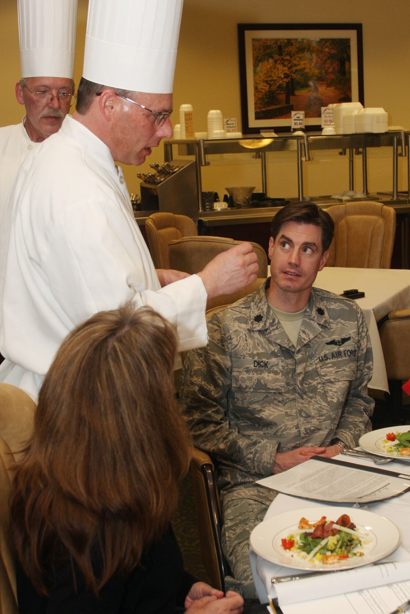 Chef Michael Medford from the 94th Services Squadron consolidated club shares preparation details about the appetizer being served to one of the judges, Lt. Col. David Dick from the 22nd Air Force during the Fer de Lance competition. (U.S. Air Force Photo/Don Peek)