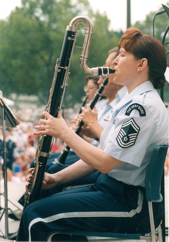 Chief Master Sgt. Elizabeth Schouten, Superintendent for The United States Air Force Band, will retire this spring, after 30 years of service in the Air Force.  She is seen here performing on Contra-alto Clarinet at the Air & Space Museum on July 4, 1998 under the direction of former Commander Lt. Col. Lowell E. Graham.