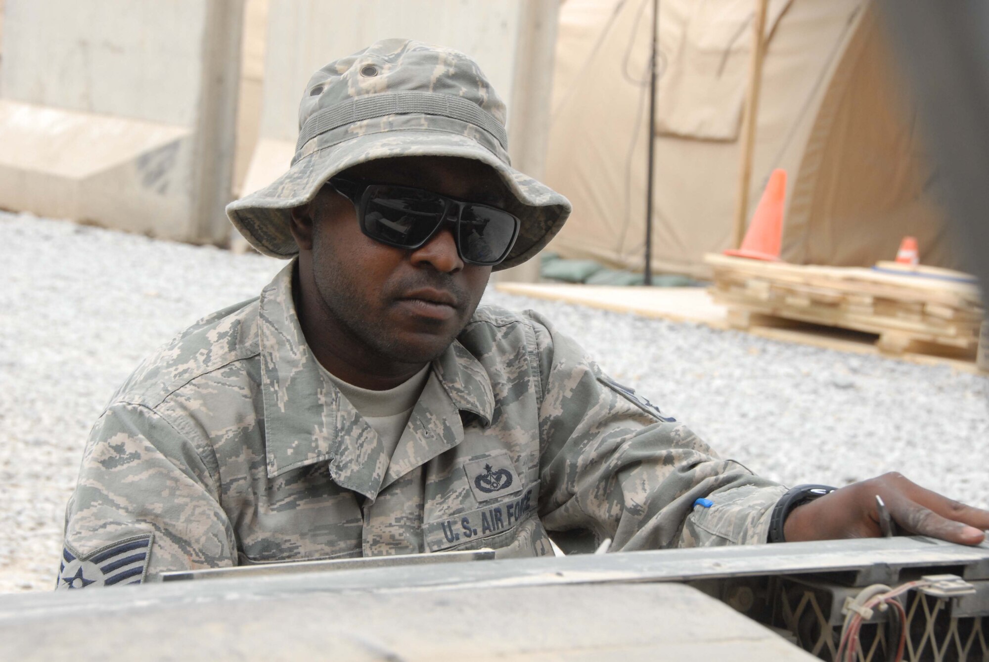 Staff Sergeant Quenton Nobles, a heating, ventilation, air conditioning and refrigeration craftsman from the 451st AEW removes a panel from an air conditioning unit at Kandahar Airfield, Afghanistan on April 28, 2011. Nobles is the only HVAC maintainer scheduled to support the wing of more than 2,000 people during the summer. (Photo by Tech. Sgt. Emily F. Alley)