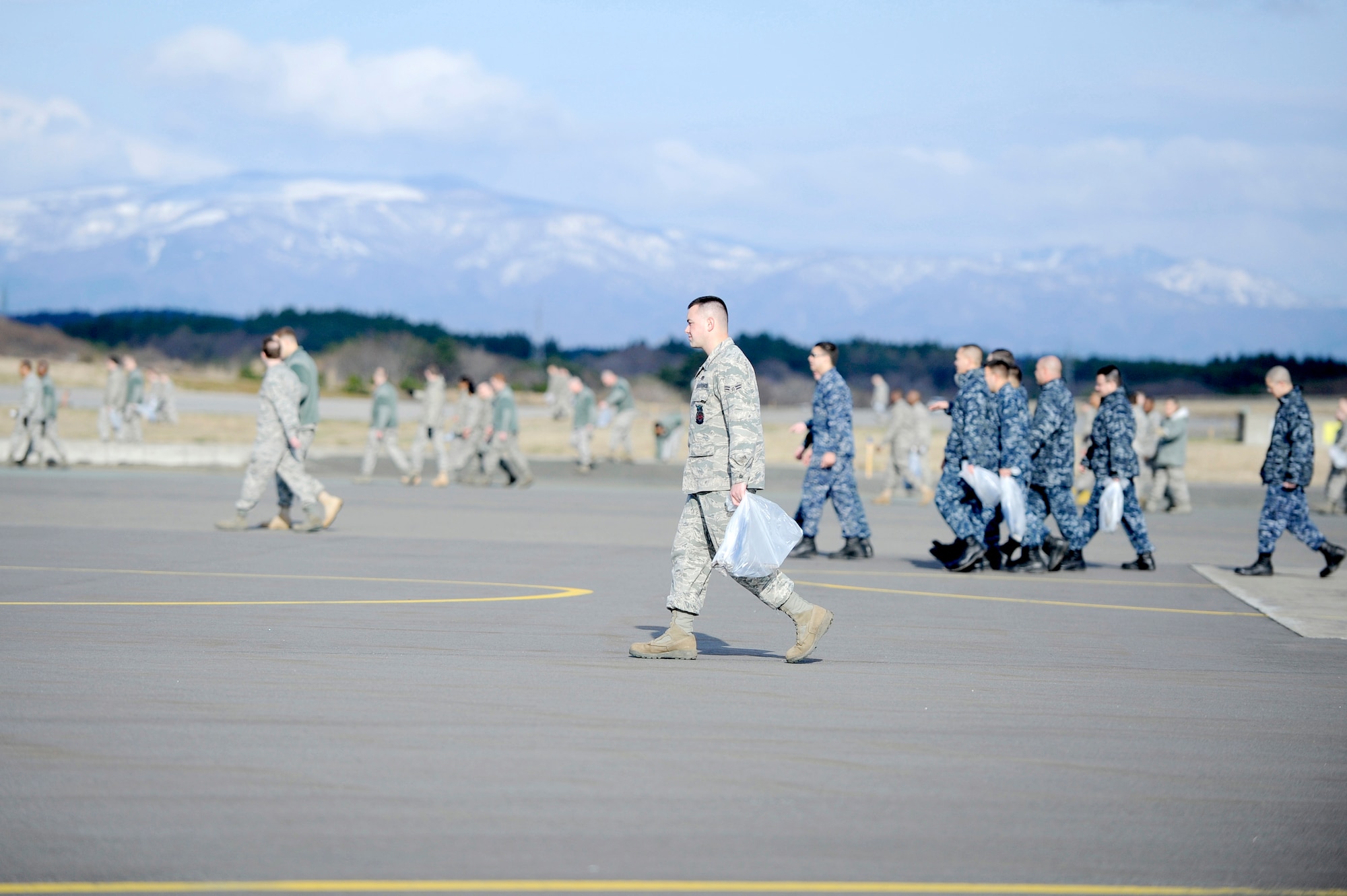 MISAWA AIR BASE, Japan -- Airmen and Sailors walk looking for foreign object damage on the airfield during the annual fighter wing FOD walk April 29. More than 1,300 Airmen and Sailors picked up FOD over a span of more than three miles. (U.S. Air Force photo/Staff Sgt. Marie Brown/Released)