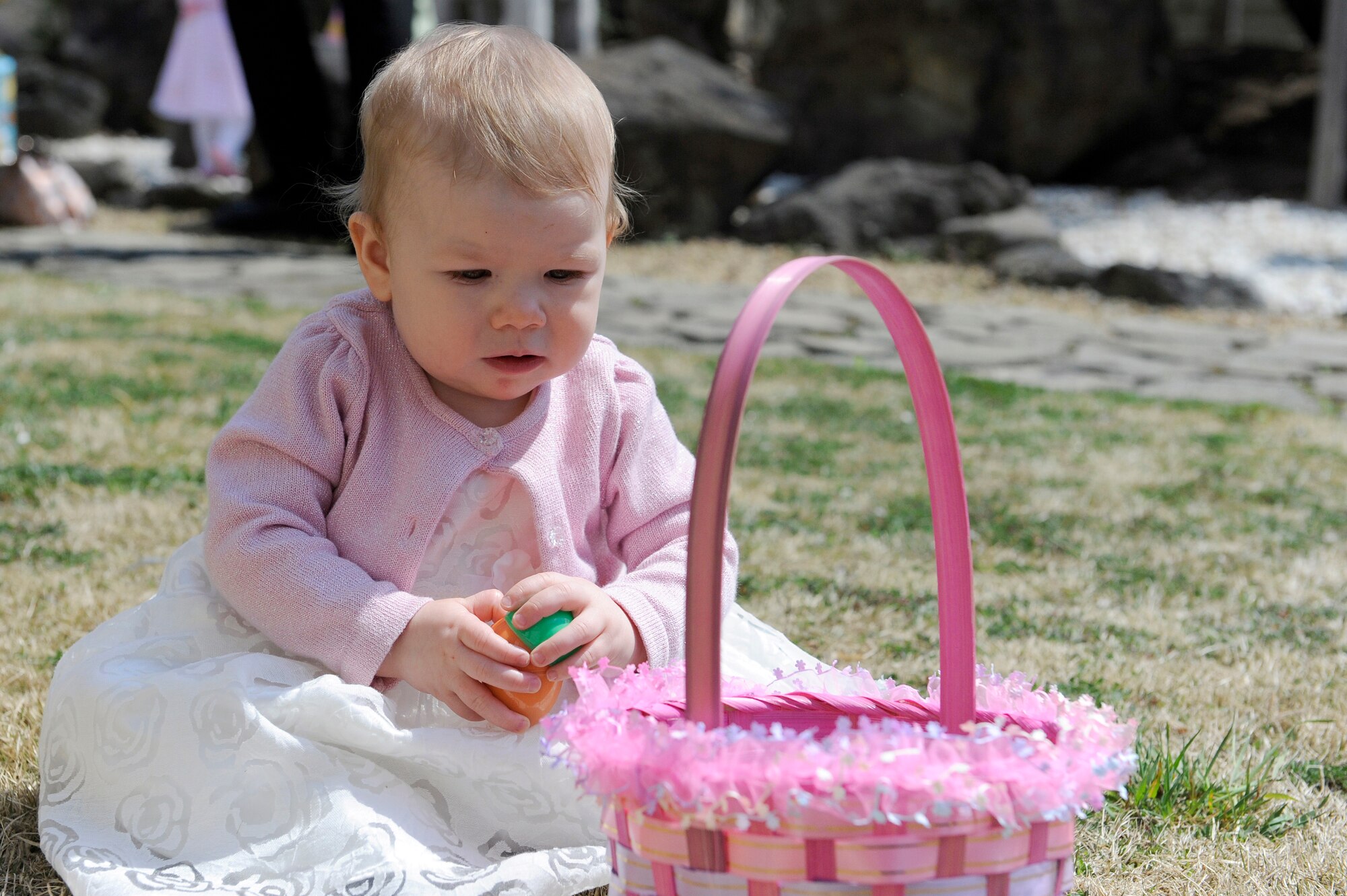 MISAWA AIR BASE, Japan -- Thirteen-month-old Avery Gill, daughter of Master Sgt. John Gill, 301st Intelligence Squadron, plays with her Easter eggs 24 April. More than 50 children participated in the Easter egg hunt sponsored by the collocated club. (U.S. Air Force photo by Staff Sgt. Marie Brown\Released)
