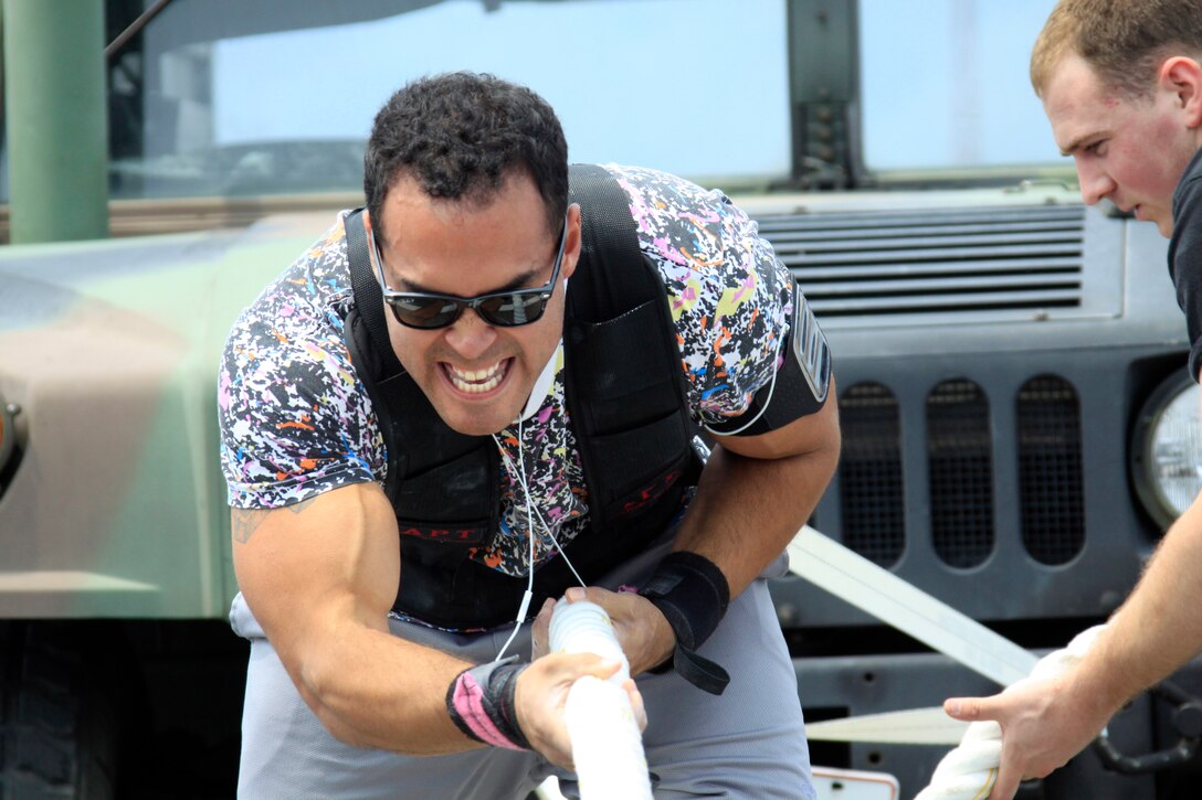 Anthony Saenz, 191-and-over pound men's weight group division competitor, puts hand over hand during the annual Iwakuni Strongman Competition at the Penny Lake field here April 30. Saenz carried 280 pounds during the farmer's walk across 122 meters, 35 7-ton tire flips, 40.46 seconds on the iron cross, 8 reps during the steel log press, and 29.02 seconds during the Humvee pull.