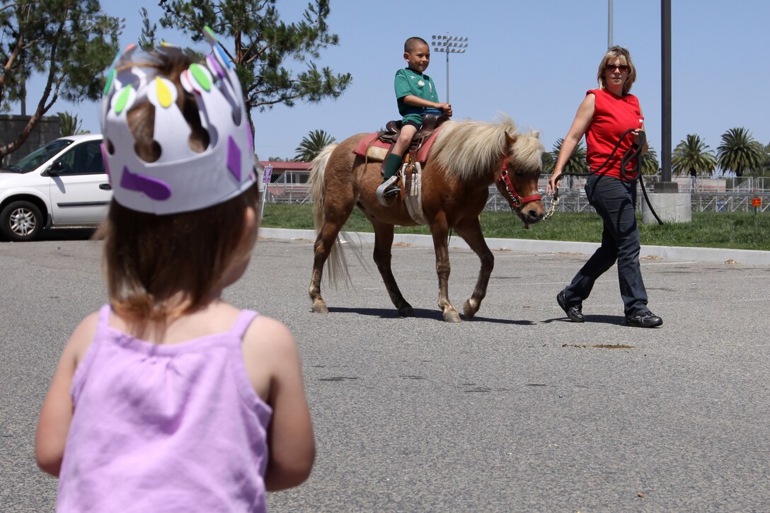 4-year-old Samantha Ulrich, anxiously awaits her turn to ride a pony during the 16th Annual Kid’s First Fair hosted by Camp Pendleton’s Marine Corps Community Services, April 30 at the Paige Fieldhouse. The event, which catered to more than 500 of the base’s youth and thier families, featured numerous events and activities such as, Zumba lessons and a martial arts demonstration conducted by Pendleton’s youth and teen programs.