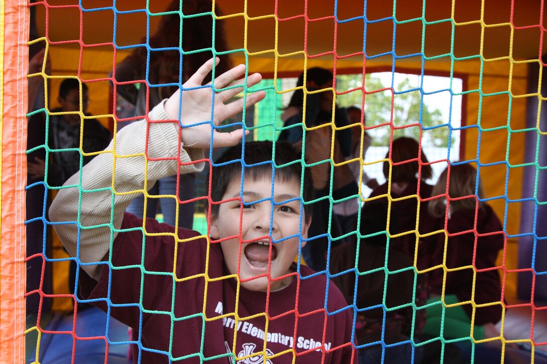 William Rudolph, a Matthew C. Perry Elementary School fourth-grader, screams and reaches for the net as he falls insode the bounce-house he was jumping in during the Month of the Military Child picnic held at the M.C. Perry soccer field here, April 29. The picnic was held to bring the Month of the Military Child to a close.