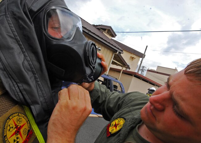 Bloomington, Minn., native, Marine Corps Sgt. Nicholas Janey, a technical rescueman with the Chemical, Biological Incident Response Force, dons his Mission Oriented Protective Posture suit with help from another CBIRF Marine prior to a bilateral demonstration at Yokota Air Base, Japan, April 23. The Marines of CBIRF and the Japan Ground Self Defense Forces demonstrated their collective ability to work together in a chemical, biological or nuclear event to Japan's Minister of Defense Toshimi Kitazawa and Air Force Lt. Gen. Burton M. Field, commander of the Joint Support Force and the United States Forces, Japan.::r::::n::::r::::n::::r::::n::