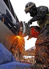 Bloomington, Minn., native, Marine Corps Sgt. Nicholas Janey, a technical rescueman with the Chemical, Biological Incident Response Force, demonstrates how he would use a saw to force his way into a vehicle to extract a person during a chemical, biological or nuclear event at Yokota Air Base, Japan, April 23. The Marines of CBIRF and the Japan Ground Self Defense Forces demonstrated their collective ability to work together in a chemical, biological or nuclear event to Japan's Minister of Defense Toshimi Kitazawa and Air Force Lt. Gen. Burton M. Field, commander of the Joint Support Force and the United States Forces, Japan.::r::::n::::r::::n::::r::::n::