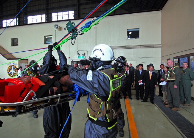 Japan's Minister of Defense Toshimi Kitazawa watches Marines with the Chemical, Biological Incident Response Force perform an extraction demonstration at Yokota Air Base, Japan, April 23. Kitazawa and Air Force Lt. Gen. Burton M. Field, commander of the Joint Support Force and the United States Forces, Japan, were on hand to watch the Marines with the CBIRF and the Japan Ground Self Defense Forces demonstrate their collective ability to work together in a chemical, biological or nuclear event.::r::::n::::r::::n::::r::::n::