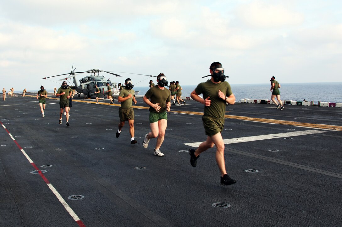 Marines with the 22nd Marine Expeditionary Unit run while wearing the M50 gas masks aboard USS Bataan in the Mediterranean Sea, April 29, 2011. Marines and sailors often conduct physical training on the flight deck before and after flight operations commence. The Marines and sailors of the 22nd MEU are currently deployed with Amphibious Squadron 6 aboard USS Bataan Amphibious Ready Group and will continue to train and improve the MEU’s ability to operate as a cohesive and effective Marine Air Ground Task Force. The 22nd MEU is a multi-mission, capable force comprised of an Aviation Combat Element, Marine Medium Tilt Rotor Squadron 263 (Reinforced); a Logistics Combat Element, Combat Logistics Battalion 22; a Ground Combat Element, Battalion Landing Team, 2nd Battalion, 2nd Marine Regiment; and its Command Element.