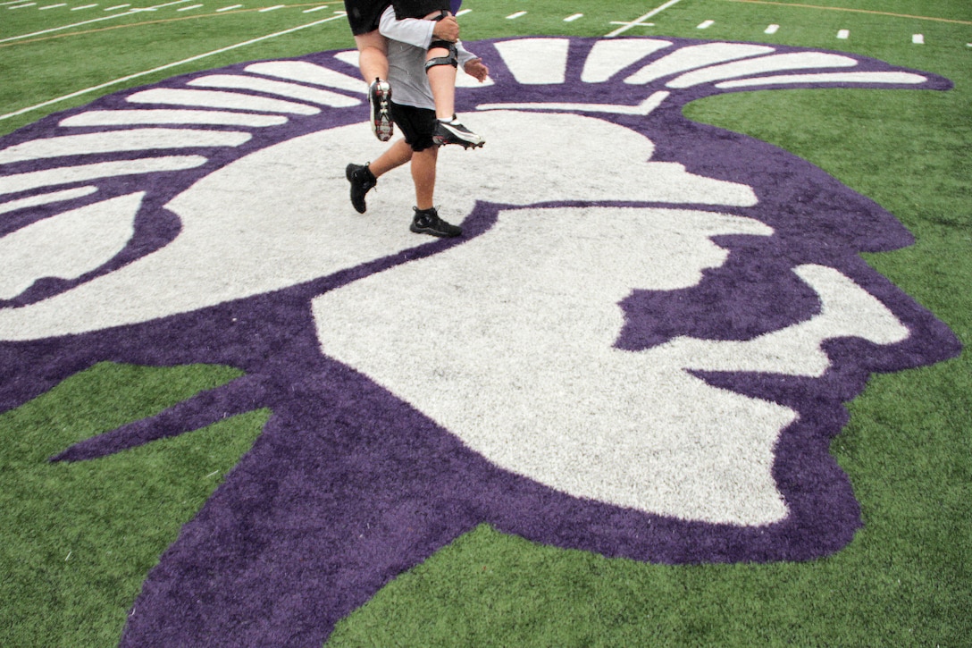 A member of the Winona State University football team carries his teammate toward the next portion of the maneuver under fire event while taking a modified combat fitness test at Maxwell Field April 30. Mankato and Rochester recruiters proctored the modified combat fitness test for more than 40 Winona State Warriors. Two weeks ago Rochester recruiters also held a leadership talk for the team, explaining how the hard the put forth on the football field will pay off once the graduate from college. For more photos of the event, visit www.facebook.com/rstwincities.