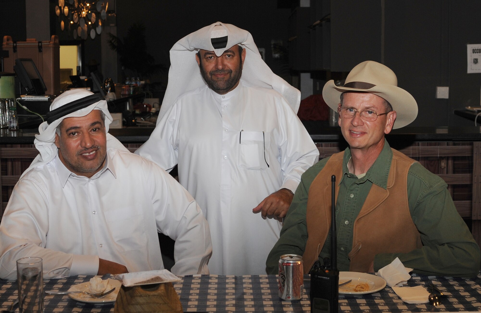 Brig. Gen. Abdulla Jassim Al Meraikhi, host nation commander, Maj. Saeed Al Marri, host nation security and Brig. Gen. Randy Kee, 379th Air Expeditionary Wing commander, pose for a picture during at Texas-style barbecue April 27 in Southwest Asia. The event also included various activities such as horseshoes and lassoing, along with a traditional western meal. (U.S. Air Force photo/Staff Sgt. Liliana Moreno)                         