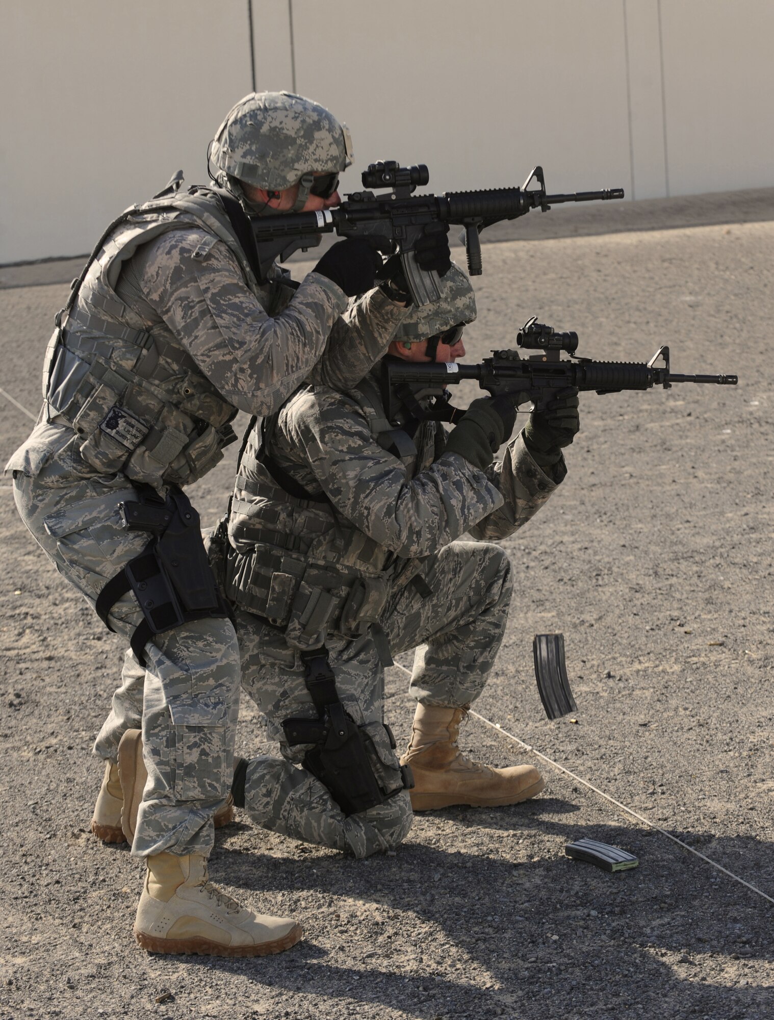 Maj. Damian Schlussel (left), 380th Expeditionary Security Forces Squadron commander, and 1st Lt. Eric Kowalski, 380th ESFS, demonstrate different tactical maneuvers while out on the firing range Mar. 4, 2011, in Southwest Asia. Security Forces must remain up to date on all training to prepare them for quick response to any real world situation, anytime. (U.S. Air Force photo by Senior Airman Maynelinne De La Cruz)
