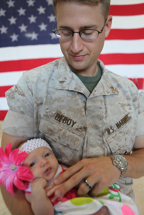 U.S. Marine Corps 1st Lt. Derek DeBoy, Battalion Adjutant, Combat Logistics Battalion 3 and his daughter await CLB-3's main body return to Marine Corps Air Station, Kaneohe Bay, Hawaii April 30, 2011. Approximately 209 Approximately 209 U.S. Marines and Sailors attached to CLB-3 spent a 7 month deployment in the Helmond River Valley, Afghanistan in support of Operation Enduring Freedom. (U.S. Marine Corps photo by Lance Cpl. Jody Lee Smith/Released)