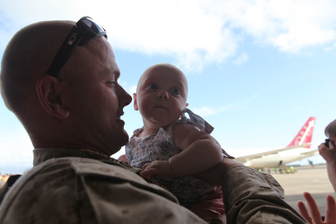 A U.S. Marine attached to Combat Logistics Battalion (CLB) 3 is welcomed home by his daughter on Marine Corps Air Station, Kaneohe Bay, Hawaii April 30, 2011. Approximately 209 Approximately 209 Marines and Sailors attached to CLB-3 spent a 7 month deployment in the Helmond River Valley, Afghanistan in support of Operation Enduring Freedom. (U.S. Marine Corps photo by Lance Cpl. Jody Lee Smith/Released)