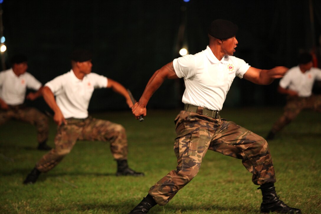 With knives in hand, sailors from the Tongan Navy demonstrate a series of martial arts techniques during the Kingdom of Tonga Military Parade and Tattoo, Aug. 2. A Tattoo is comprised of military units – musical and operational – from different countries collaborating in an extensive exhibition of musical performances and demonstrating military capabilities.