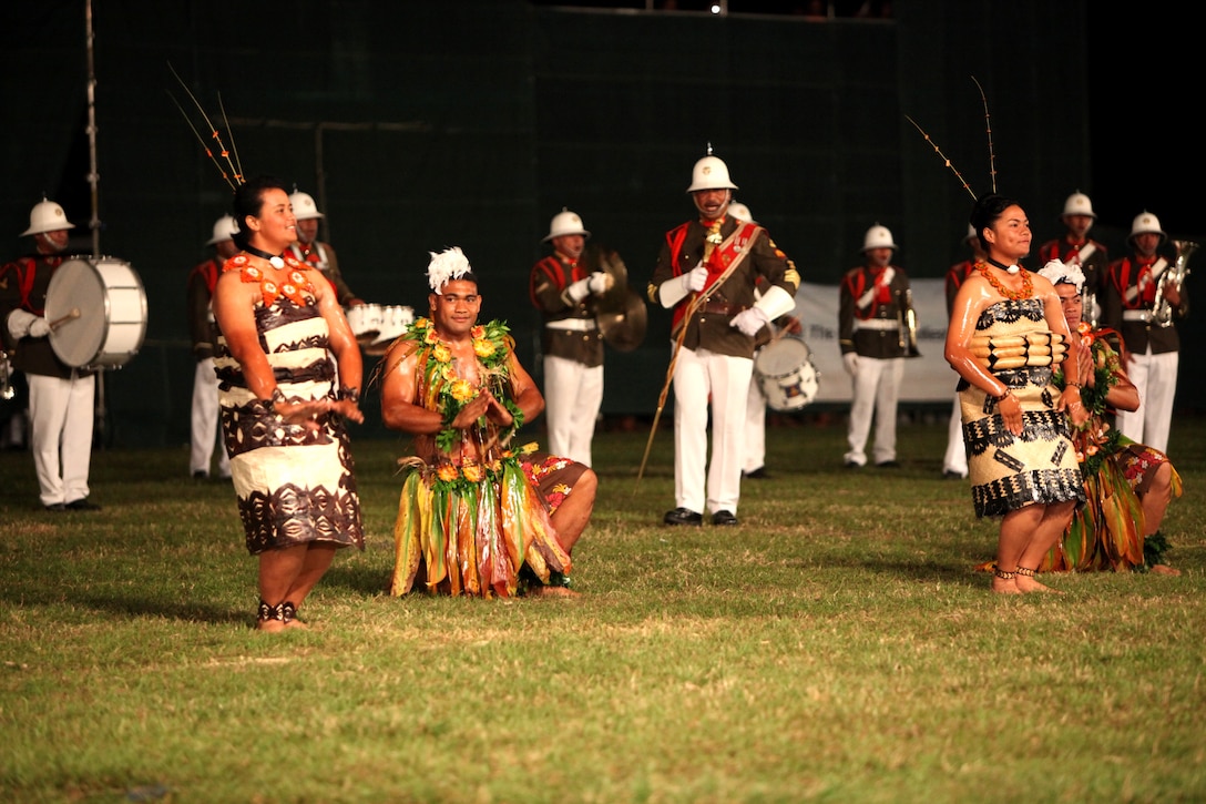 Tongan performers dance the tau’olunga while the Royal Corps of Musicians play music during the Kingdom of Tonga Military Parade and Tattoo, Aug. 2. A Tattoo is comprised of military units – musical and operational – from different countries collaborating in an extensive exhibition of musical performances and demonstrating military capabilities.