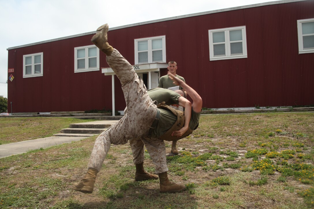 Lance Cpl. Joseph Sanchez, a reproduction specialist with 2nd MAW Combat Camera, practices a MCMAP hip throw on Lance Cpl. Nicholas Blackketter, an operations divisions training clerk with MWHS-2, during a MCMAP course. the course was  led by Staff Sgt. Timothy Hopkins, a Marine Corps Instructor of Water Survival at the Marine Corps Cherry Point Combat Pool, who taught the two-week course to 2nd MAW Marines to advance in their belts from gray to green or green to brown. ::r::::n::::r::::n::