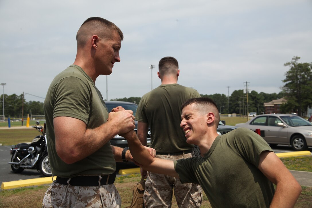 Staff Sgt. Timothy Hopkins, a Marine Corps Martial Arts Program black belt,  teaches Lance Cpl. Joseph Sanchez a reproduction specialist with 2nd MAW Combat Camera proper pain techniques during a two-week Marine Corps Martial Arts Program course. The