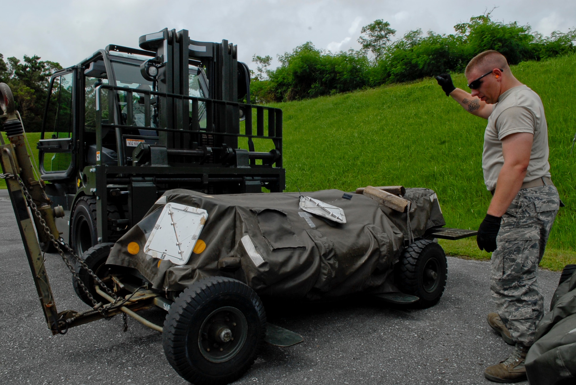 Staff Sgts. David Logue and Kenny Richanrdson, 18th Munitions Squadron equipment maintenance crew chiefs, work together to accurately align a loader while preparing  a trailer for a payload at Kadena Air Base July 26. Trailers at Kadena are used for everyday operations, deployments and others are kept on reserve for other base’s possible shortage during deployment. (U.S. Air Force photo/ Airman 1st Class Tara A. Williamson)