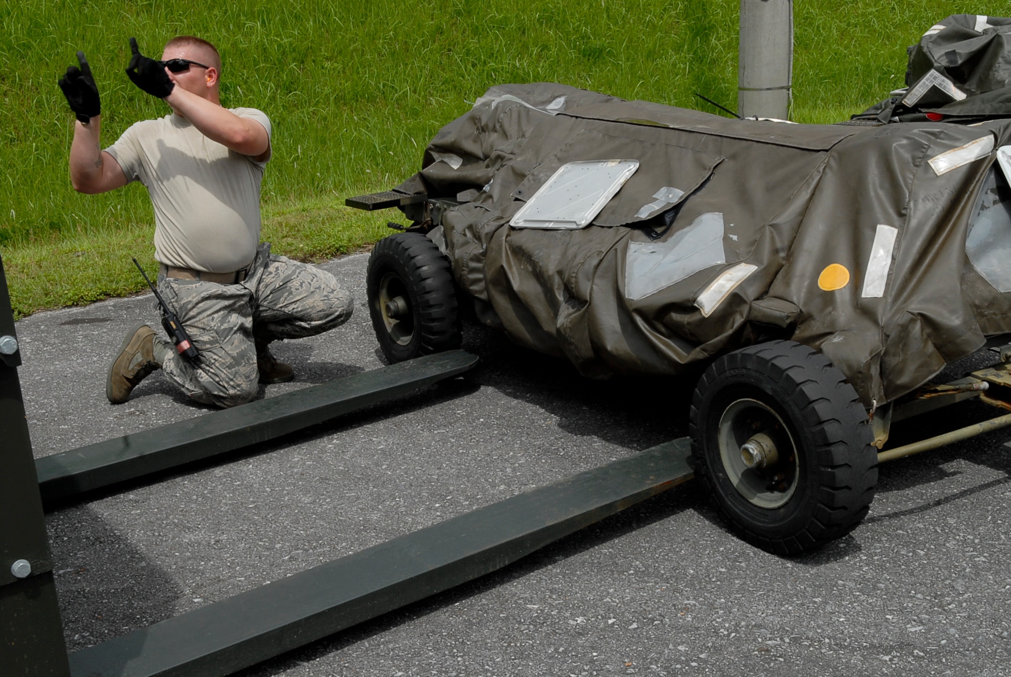 Staff Sgt. David Logue, 18th Munitions Squadron equipment maintenance crew chief, gives careful directions as a munitions trailer is prepared to be loaded July 26. Many of Kadena's munitions trailers are stored for use on deployments or when other bases in the region run short. (U.S. Air Force photo/ Airman 1st Class Tara A. Williamson)