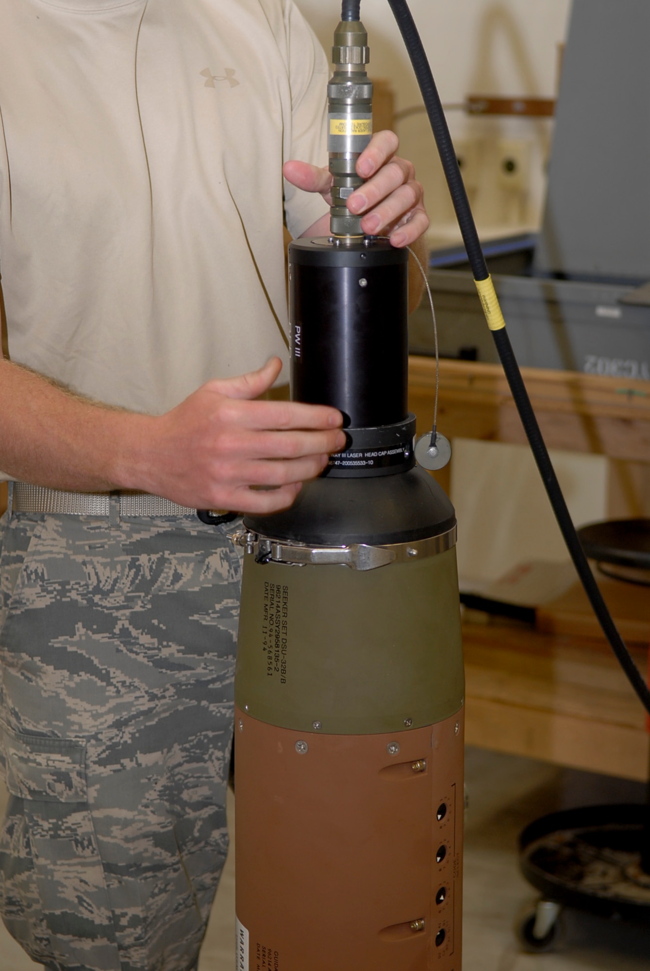 Airman 1st Class Trevor Mortensen, 18th Munitions Squadron conventional maintenance crew chief, secures a laser used for testing equipment to ensure proper working order July 26. Each of the munitions must be tested regularly for proficiency. (U.S. Air Force photo/ Airman 1st Class Tara A. Williamson)