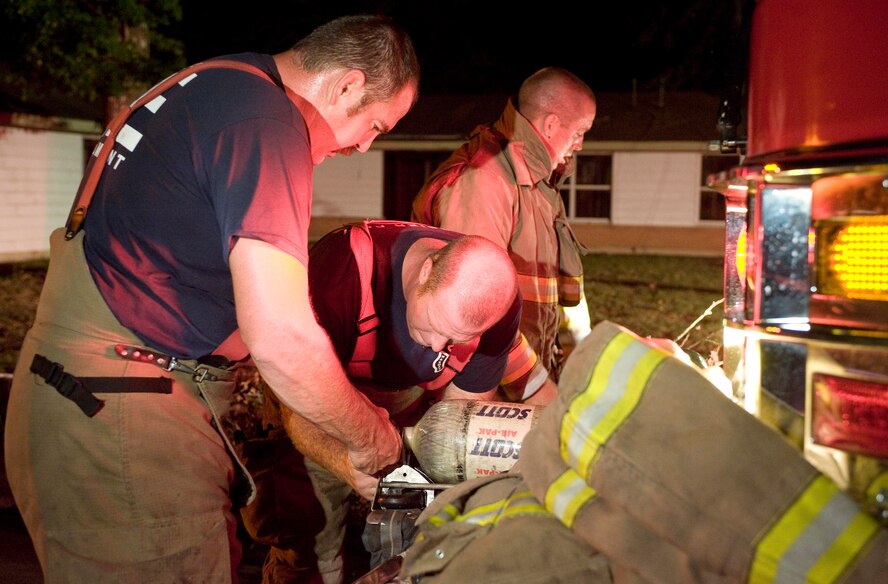Firefighters with the Bossier City Fire Department check their oxygen tanks during a training scenario on Barksdale Air Force Base; La., July 28. The scenario was part of a joint training exercise between the Barksdale firefighters and the Bossier City force. (U.S. Air Force photo/Senior Airman Chad Warren)(RELEASED)