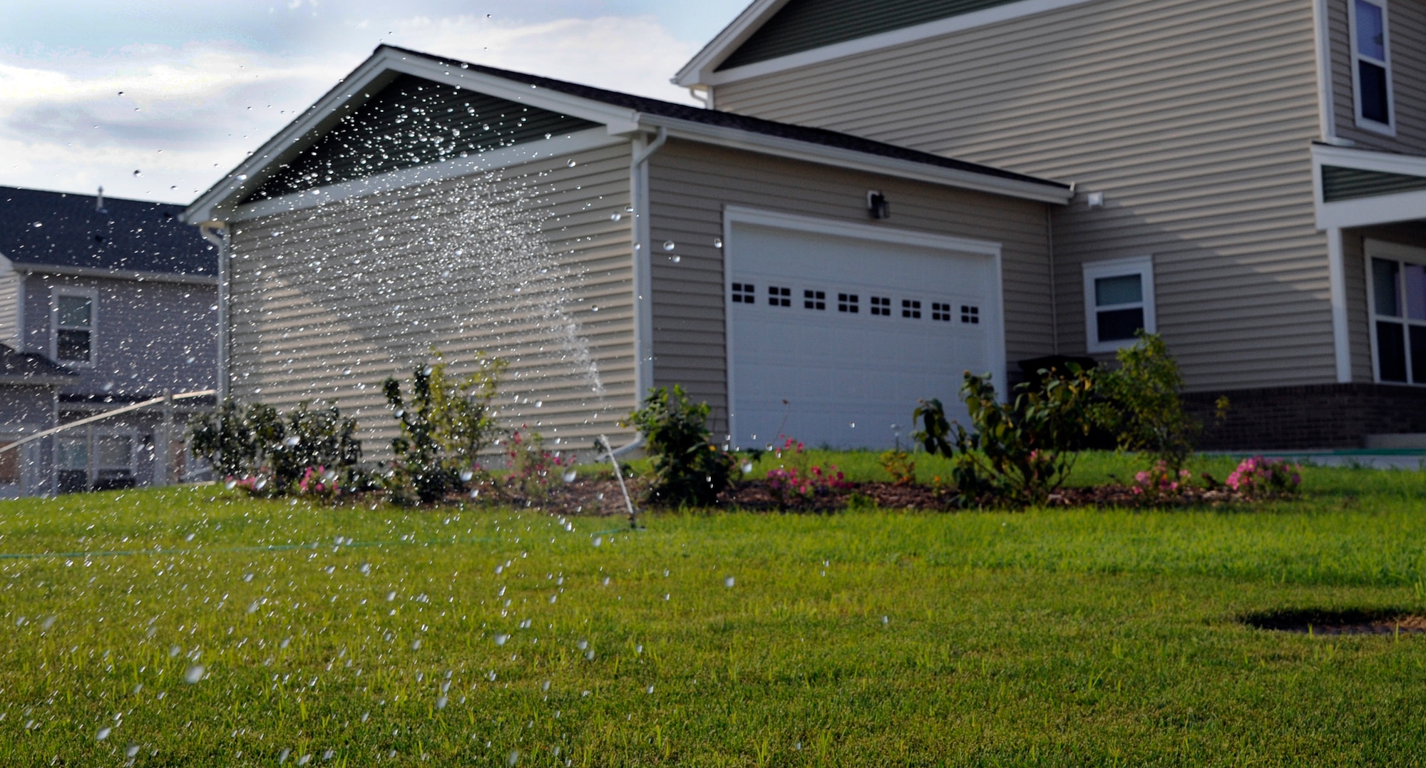 WHITEMAN AIR FORCE BASE, Mo. - A sprinkler waters lawns in base housing here July 28, 2011. The base housing office recommends all occupants to water their lawn up to one inch per week, whether its by rain or applied water. (U.S. Air Force photo by Airman 1st Class Cody H. Ramirez)