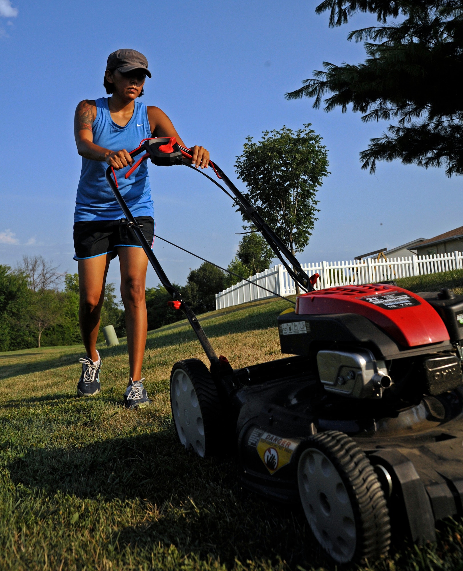 WHITEMAN AIR FORCE BASE, Mo. - Gina Daniel, wife of Staff Sgt. Steven Daniel, 509th Maintenance Squadron, mowes her lawn July 28, 2011. The base housing office here recommends mowing as necessary to maintain a neat appearance. Specific requirements can be found in a brochure at the base housing office here. (U.S. Air Force photo by Airman 1st Class Cody H. Ramirez)
