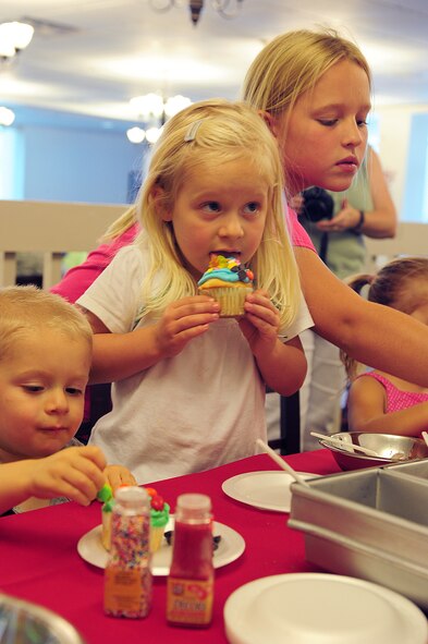 Hailey, daughter of Maj. James Meier, 824th Base Defense Squadron commander, enjoys her cupcake at the Georgia Pines Dining Facility at Moody Air Force Base, Ga. July 28, 2011. Hailey decorated her cupcake with blue icing, lots of gummy bears and sprinkles during the second annual Bring Your Child to Work Day. (U.S. Air Force photo by Senior Airman Stephanie Mancha/Released)