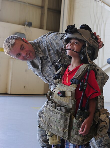 U.S. Air Force Staff Sgt. Jon Smith, 38th Rescue Squadron pararescueman, helps Gabriel, son of Staff Sgt. David Bristow, 820th Combat Operations Squadron assistant NCO in charge of armor, with putting on pararescuemen Kit body armor and Kevlar at Moody Air Force Base, Ga., July 28, 2011. Children were also allowed to wear night vision goggles in a dark room during the pararescuemen static display. (U.S. Air Force photo by Senior Airman Stephanie Mancha/Released)