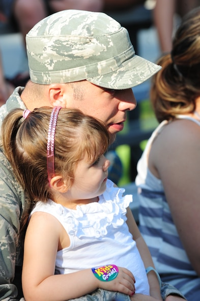 U.S. Air Force Staff Sgt. Steven Johnson, 723rd Aircraft Maintenance Squadron weapons armament systems, and daughter Renee watch the 820th Combat Operations  Squadron  military working dog and its handler demonstrate different   scenarios  during the Bring Your Child to Work Day at Moody Air Force Base, Ga., July 28, 2011. The demonstration showed how a MWD and its handler work together to seize and search a suspect. (U.S. Air Force photo by Senior Airman Stephanie Mancha/Released)