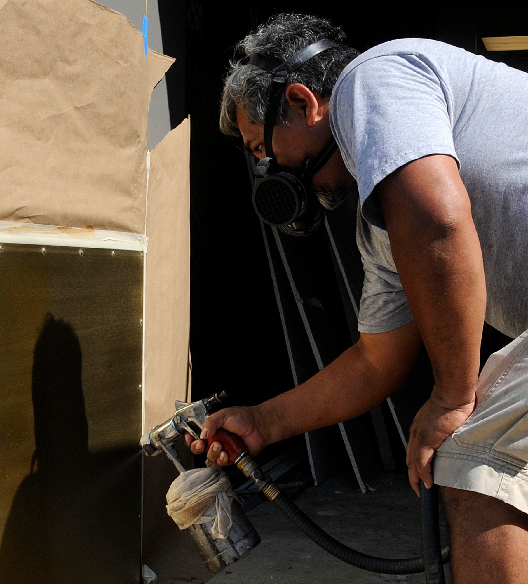 Juan Rios, metal finisher, sprays finishing gloss onto doors of the new Langley Inn visitor?s quarters at Langley Air Force Base, Va., July 29, 2011. The new inn, located on Nealy Avenue, boasts 210 units and is scheduled to open to the public Aug. 31. (U.S. Air Force photo by Staff Sgt. Dana Hill/Released)