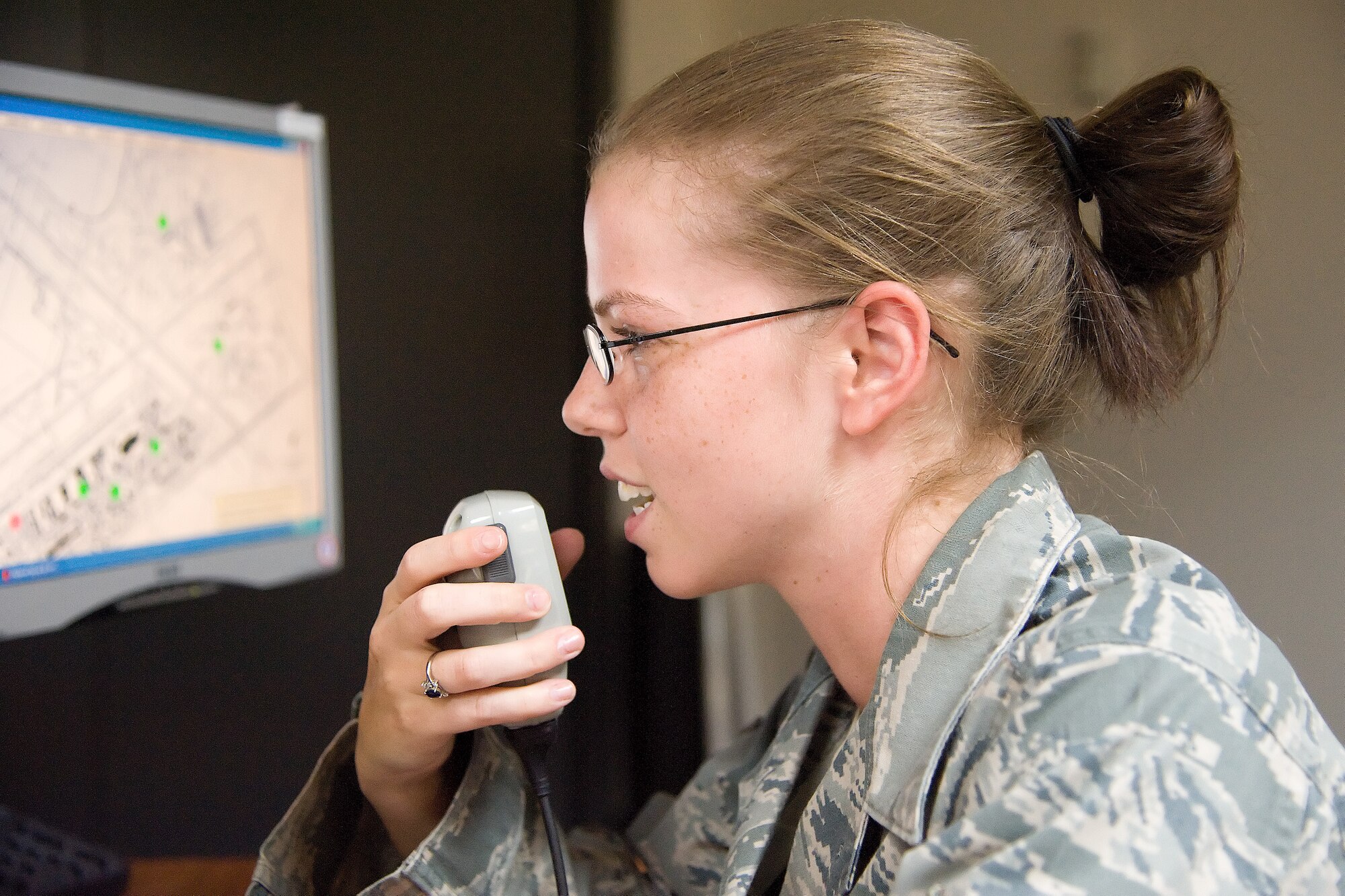 Senior Airman Meagan Orebaugh, a command and control specialist with the 436th Airlift Wing Command Post, makes a radio call July 27, 2011, at the command post at Dover Air Force Base, Del. Command and control specialist are responsible for receiving information, monitoring flightline operations, mission management and notifying participating parties of ongoing operations or alerts. (U.S. Air Force photo by Adrian Rowan)