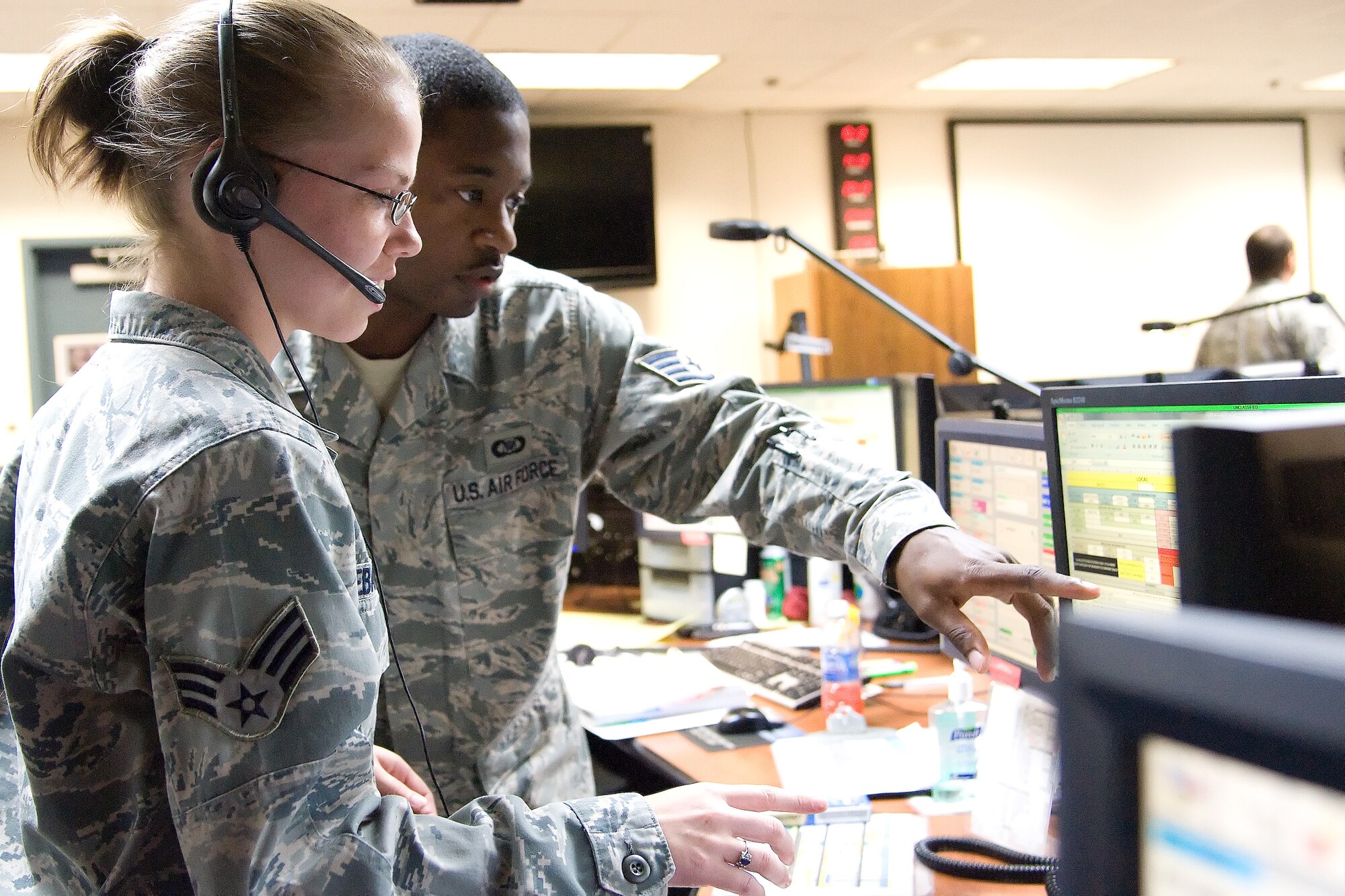 Senior Airman Meagan Orebaugh (left) and Staff Sgt. Reshon Wilburn, both command and control specialist with the 436th Airlift Wing Command Post, work a phone call July 27, 2011, at the command post at Dover Air Force Base, Del. Command and control specialist are responsible for receiving information, monitoring flightline operations, mission management and notifying participating parties of ongoing operations or alerts. (U.S. Air Force photo by Adrian Rowan)